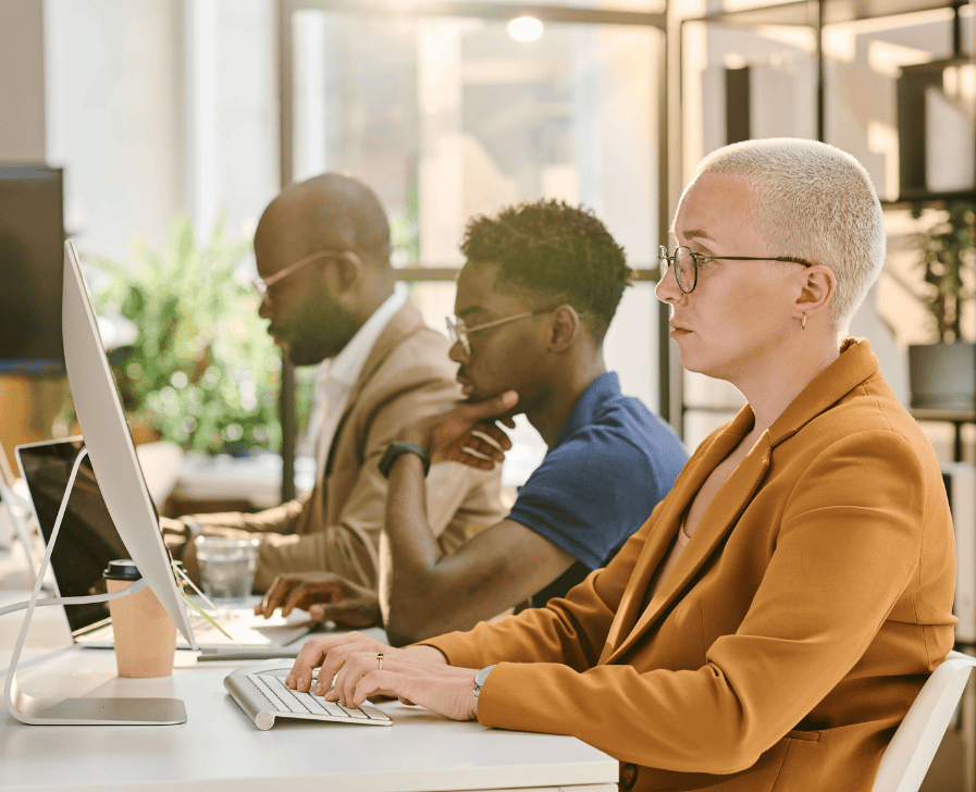 Three people working at computers.